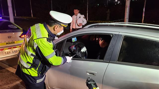 교통경찰관이 지난 18일 경기 광주 역동삼거리에서 일회용 덮개를 씌운 비접촉식 감지기로 단속하는 모습. 뉴스1