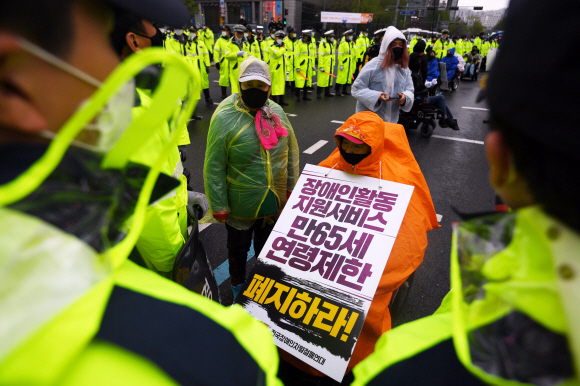 장애인의 날인 20일 서울 광화문 광장에서 전국장애인차별철폐연대 활동가들이 집단수용 장애인 거주시설 폐쇄와 장애등급제 폐지 등 요구사항을 적은 피켓을 목에 걸고 대학로 방향으로 행진을 준비하고 있다. 2020.4.20 박윤슬 기자 seul@seoul.co.kr