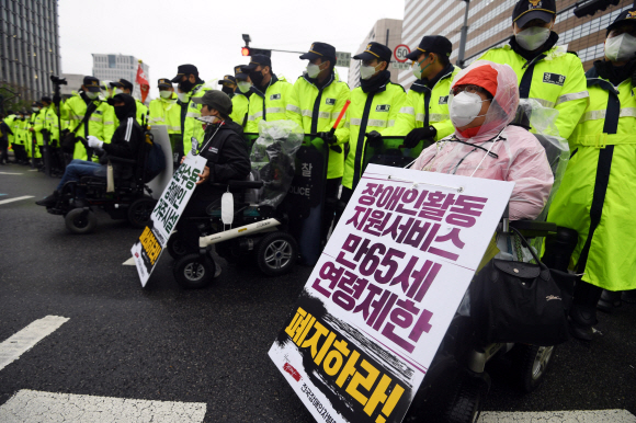장애인의 날인 20일 서울 광화문 광장에서 전국장애인차별철폐연대 활동가들이 집단수용 장애인 거주시설 폐쇄와 장애등급제 폐지 등 요구사항을 적은 피켓을 목에 걸고 대학로 방향으로 행진을 준비하고 있다. 2020.4.20 박윤슬 기자 seul@seoul.co.kr
