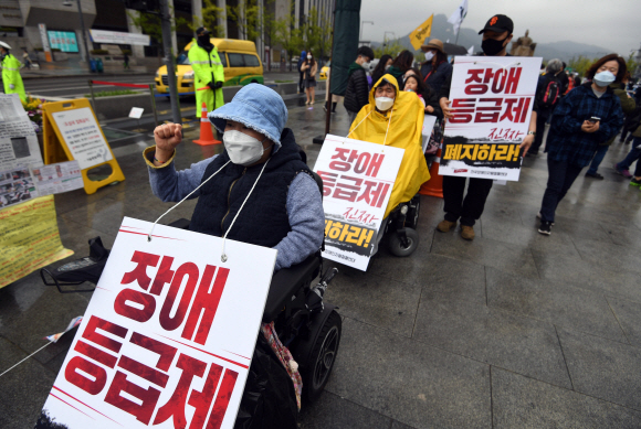 장애인의 날인 20일 서울 광화문 광장에서 전국장애인차별철폐연대 활동가들이 집단수용 장애인 거주시설 폐쇄와 장애등급제 폐지 등 요구사항을 적은 피켓을 목에 걸고 대학로 방향으로 행진을 준비하고 있다. 2020.4.20 박윤슬 기자 seul@seoul.co.kr