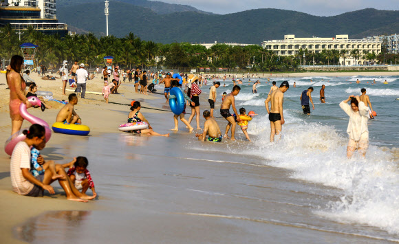 20일(현지시간)  중국 남부 하이난성 산야에서 사람들이 해변에서 즐거운 시간을 보내고 있다. AFP 연합뉴스