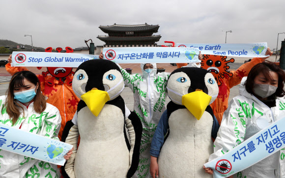 지구의 날인 22일 오전 서울 광화문 광장에서 환경보건시민센터 활동가들이 코로나19 사태의 근본 원인은 생태계 파괴와 기후변화라며 환경문제에 범국민적 관심을 촉구하는 퍼포먼스를 하고 있다. 2020.4.22  연합뉴스