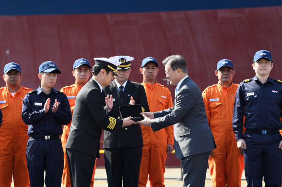 문재인 대통령이 23일 경남 거제시 대우조선해양 옥포조선소에서 열린 세계 최대 컨테이너선 ‘알헤시라스’호(2만4천TEU급) 명명식에 참석해 전기운 선장에게 윤도(전통나침반)을 전달하고 있다. 2020. 4. 23 도준석 기자pado@seoul.co.kr