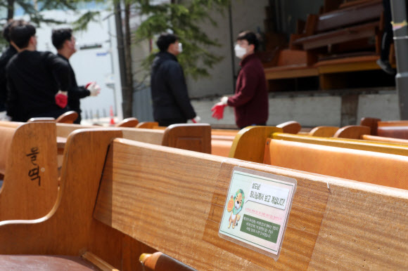 지난 20일 경기 과천시 별양동의 ‘신천지교회’ 예배당 건물 앞에서 관계자들이 예배에 쓰였던 목회용 의자를 내놓고 있다. 신천지 측은 이날부터 지난 13년 동안 불법으로 사용했던 과천시 일대 총회 본부와 예배당 시설의 자진 철거에 들어갔다.  연합뉴스 