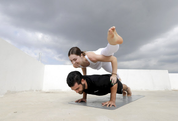 27일(현지시간) 레바논 베이루트의 한 아파트 옥상에서 요가 강사 커플이 아크로 요가를 선보이고 있다.  AFP 연합뉴스
