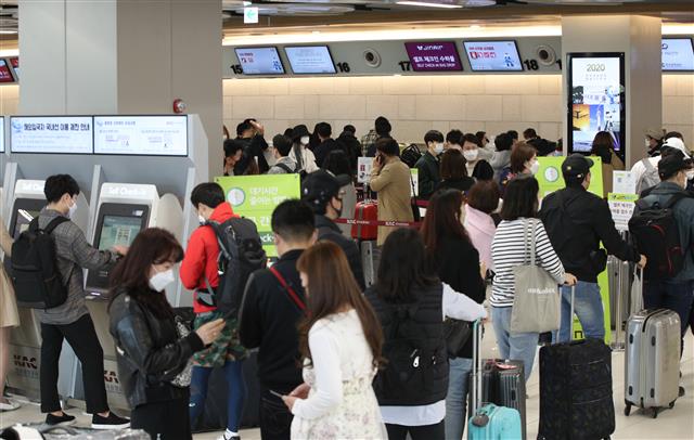 본격적인 황금연휴가 시작된 30일 오전 서울 강서구 김포공항 국내선 청사가 탑승객들로 붐비고 있다.  제주도관광협회는 황금연휴가 시작된 지난 29일 제주 방문객이 신종 코로나바이러스 감염증(코로나19) 사태 이후 최다인 3만6587명으로 잠정 집계됐다고 밝혔다. 이는 코로나19의 세계적 대유행으로 국제선 하늘길이 막히고 해외여행을 다녀오더라도 2주간 자가격리를 해야하는 등 사실상 해외여행이 불가능해지면서 관광객들이 제주로 몰리는 것으로 풀이된다. 2020.4.30 뉴스1
