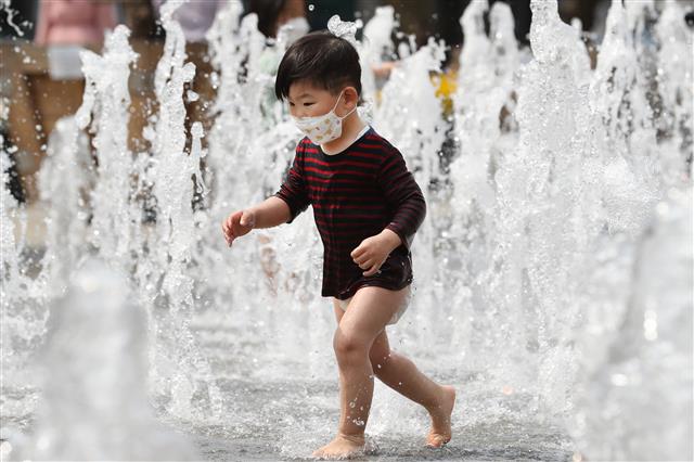 전국이 25도 안팎의 기온을 보이는 황금연휴 첫 날인 30일 오후 서울 광화문광장 분수대를 찾은 어린이가 물놀이를 하며 더위를 잊고 있다. 2020.4.30 뉴스1