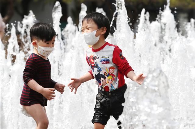 전국이 25도 안팎의 기온을 보이는 황금연휴 첫 날인 30일 오후 서울 광화문광장 분수대를 찾은 어린이들이 물놀이를 하며 더위를 잊고 있다. 2020.4.30 뉴스1