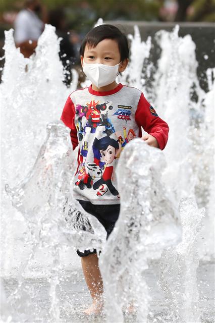 전국이 25도 안팎의 기온을 보이는 황금연휴 첫 날인 30일 오후 서울 광화문광장 분수대를 찾은 어린이가 물놀이를 하며 더위를 잊고 있다. 2020.4.30 뉴스1