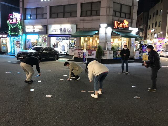 서울 광진구청 직원들이 지난 4월 구의동 미가로 맛의 거리에 살포된 불법 유해전단지를 수거하고 있다. 2020.5.1. 광진구 제공