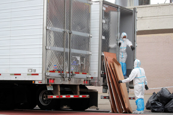 미국 뉴욕 브루클린의 앤드루 T. 클래클리 장례식장 직원들이 지난달 30일(현지시간) 시신들을 냉동트럭으로 옮기고 있다.  로이터 연합뉴스