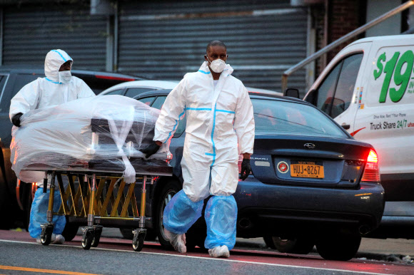 미국 뉴욕 브루클린의 앤드루 T. 클래클리 장례식장 직원들이 지난달 30일(현지시간) 시신들을 냉동트럭으로 옮기고 있다.  로이터 연합뉴스