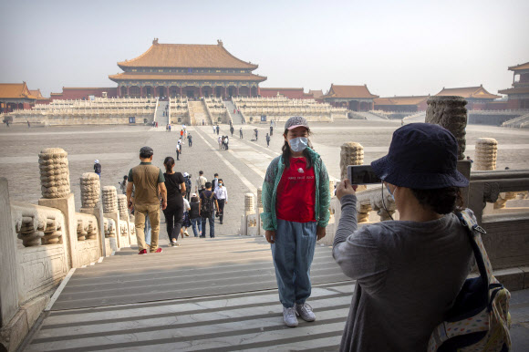 중국 베이징 자금성이 1일 코로나 사태 이후 3개월여 만에 문을 열자 관광객들이 마스크를 쓰고 사진을 찍고 있다. 연합뉴스