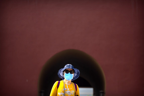 중국 노동절 연휴가 시작된 1일(현지시간) 코로나19로 문을 닫았던 자금성이 3개월여 만에 재개장하자 마스크를 쓴 관람객이 방문하고 있다. AP 연합뉴스