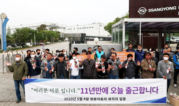 한상균 전 민주노총 위원장, 김득중 금속노조 쌍용자동차 지부장 등 쌍용자동차 해고노동자 중 마지막 복직자들이 4일 오전 경기도 평택시 쌍용자동차 평택공장 앞에서 첫 출근을 하며 손을 흔들고 있다. 2020.5.4  연합뉴스