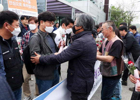 쌍용자동차 해고노동자 중 마지막 복직자들이 4일 오전 경기도 평택시 쌍용자동차 평택공장 앞에서 출근 축하 장미꽃을 받고 있다. 2020.5.4  연합뉴스