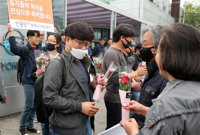 한상균 전 전국민주노동조합총연맹 위원장을 비롯해 11년 만에 출근하는 쌍용자동차 마지막 해고자들이 4일 오전 경기도 평택시 쌍용자동차 본사에서 출근에 앞서 축하 꽃을 받고 있다. 2020.5.4 뉴스1