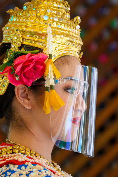 태국 전통 무용수가 3일(현지시간) 방콕 에라완 사원에서 코로나19 에방용 얼굴 보호구를 착용하고 있다. AFP 연합뉴스