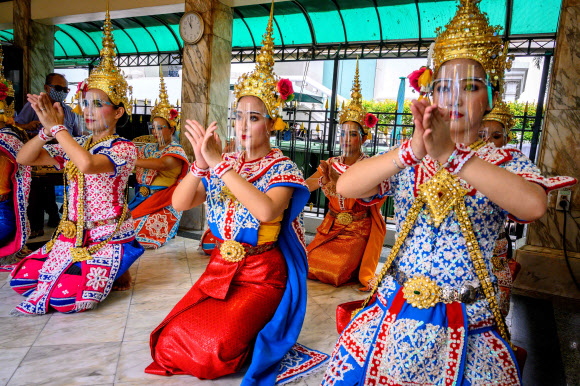 태국 전통 무용수들이 3일(현지시간) 방콕 에라완 사원에서 코로나19 에방용 얼굴 보호구를 착용하고 공연을 하고 있다. AFP 연합뉴스