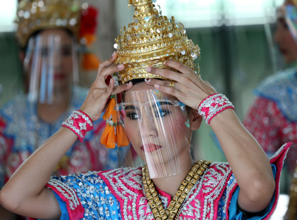 태국 전통 무용수가 3일(현지시간) 방콕 에라완 사원에서 코로나19 에방용 얼굴 보호구를 착용하고 있다. EPA 연합뉴스