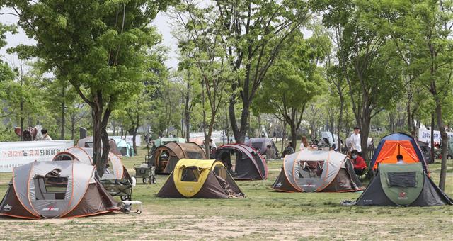 4일 서울 여의도 한강공원을 찾은 시민들이 그늘막 텐트를 치고 황금연휴를 즐기고 있다. 코로나19 예방을 위한 ‘사회적 거리두기’는 황금연휴가 끝나는 5일까지 이어지고 6일부터 ‘생활 속 거리두기’로 전환된다. 뉴스1