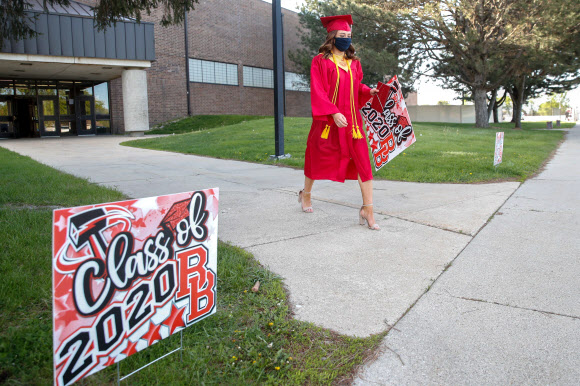 학생 미아 와일리가 6일(현지시간) 일리노이 주 브래들리에서 졸업식에서 졸업장을 받은 후, 브래들리-버보니스 커뮤니티 고등학교를 떠날 때 마스크를 쓰고 있다. AFP 연합뉴스
