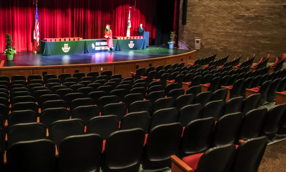 한 졸업생이 6일(현지시간) 미국 일리노이주 브래들리에서 브래들리-버보니스 커뮤니티 고등학교 졸업식에서 마스크를 들고 졸업장을 가져가려 하고 있다. EPA 연합뉴스