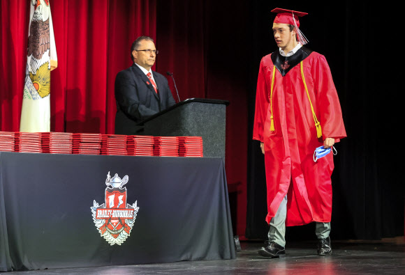 한 졸업생이 6일(현지시간) 미국 일리노이주 브래들리에서 브래들리-버보니스 커뮤니티 고등학교 졸업식에서 마스크를 들고 졸업장을 가져가려 하고 있다. EPA 연합뉴스