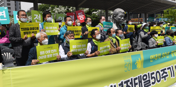 7일 서울 평화시장 앞 전태일다리에서 열린 아름다운청년전태일50주기 범국민행사위원회 출범식에서 김동명 한국노총 위원장과 김명환 민주노총 위원장을 비롯한 참석자들이 전태일 열사를 추모하는 손피켓을 들고 있다. 2020.5.7 오장환 기자 5zzang@seoul.co.kr