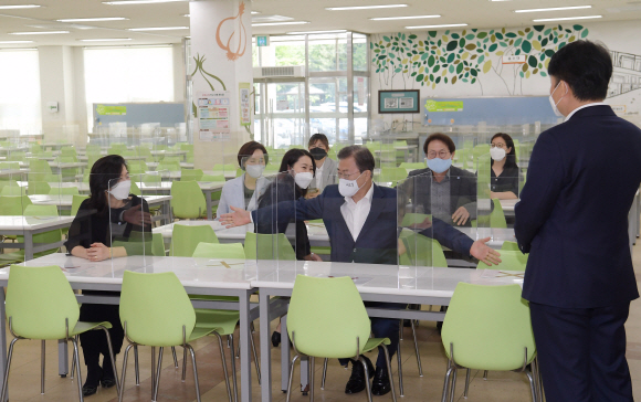문재인 대통령이 8일 코로나19 사태로 인해 등교개학이 거듭 연기되었다가 다음 주 등교개학을 앞둔 서울 용산 중경고등학교를 방문, 개학 준비상황을 직접 점검하고 철저한 대비를 당부했다. 학교 급식실을 방문한 문대통령이 학부모들과 의자에 착석해서 좌석간 이격거리를 확인하고 있다.  2020.5.8 도준석 기자 pado@seoul.co.kr
