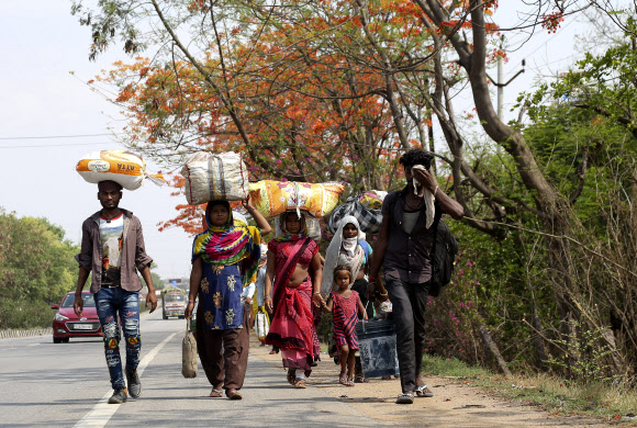 코로나19 확산을 막기 위해 국가 봉쇄령이 내려진 인도 하이데라바드의 이주 노동자들이 8일(현지시간) 고향 마을로 돌아가기 위해 걸어가고 있다. 하이데라바드 AP 연합뉴스 