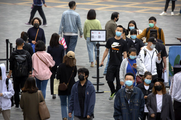 중국 베이징의 한 쇼핑거리에서 9일 마스크를 쓴 시민들이 체온 확인을 받고 있다. 2020.5.9  AP 연합뉴스
