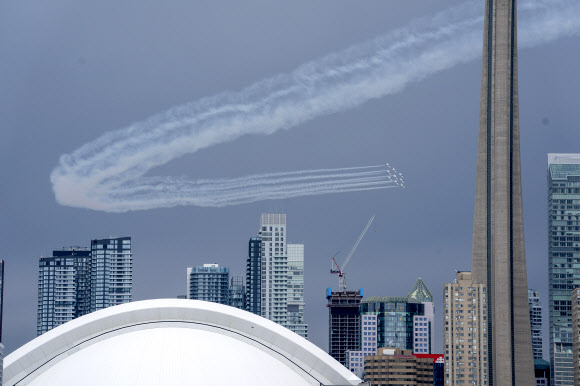 캐나다 스노우버드(캐나다 공군 곡예비행팀)이 10일(현지시간) 캐나다 토론토에서 코로나19 대유행 기간 동안, 토론토 스카이라인을 돌며 멋진 비행을 선보이고 있다. AP 연합뉴스