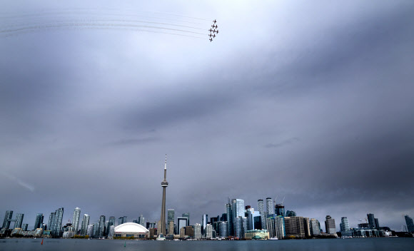 캐나다 스노우버드(캐나다 공군 곡예비행팀)이 10일(현지시간) 캐나다 토론토에서 코로나19 대유행 기간 동안, 토론토 스카이라인을 돌며 멋진 비행을 선보이고 있다. AP 연합뉴스