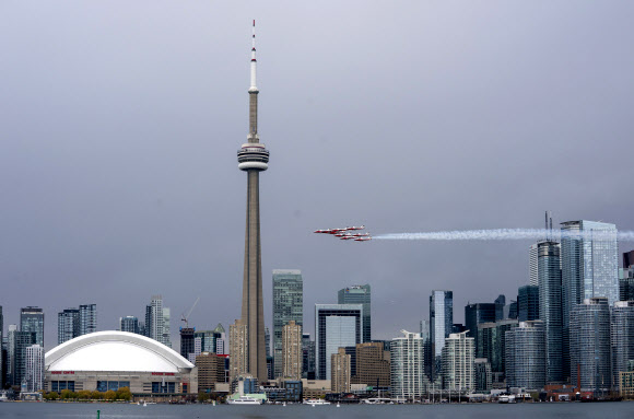 캐나다 스노우버드(캐나다 공군 곡예비행팀)이 10일(현지시간) 캐나다 토론토에서 코로나19 대유행 기간 동안, 토론토 스카이라인을 돌며 멋진 비행을 선보이고 있다. AP 연합뉴스