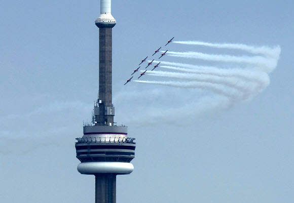 캐나다 스노우버드(캐나다 공군 곡예비행팀)이 10일(현지시간) 캐나다 토론토에서 코로나19 대유행 기간 동안, CN 타워를 돌며 멋진 비행을 선보이고 있다. AP 연합뉴스