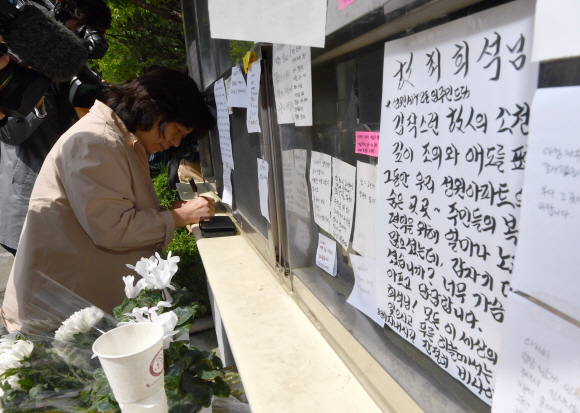 11일 서울 성북구의 한 아파트 경비실 앞에서 입주민이  ‘주민 갑질’을 견디지 못하고 전날 극단적 선택을 한 경비원 A를 추모하기 위해 메시지를 남기고 있다. 2020.5.11 박지환기자 popocar@seoul.co.kr