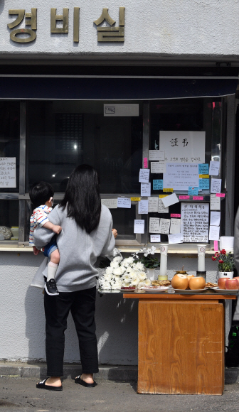 11일 서울 성북구의 한 아파트 경비실 앞에서 입주민이  ‘주민 갑질’을 견디지 못하고 전날 극단적 선택을 한 경비원 A를 추모하기 위해 메시지를 남기고 있다. 2020.5.11 박지환 기자 popocar@seoul.co.kr