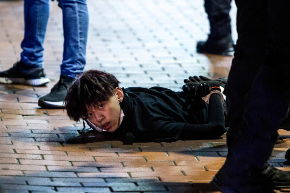 지난 10일 홍콩에서 송환법 반대 시위가 재개된 가운데 몽콕 지역에서 민주화 요구 집회에 참가했던 한 시위자가 경찰에 체포돼 수갑을 찬 채로 바닥에 엎드려 있다. 홍콩 AFP 연합뉴스