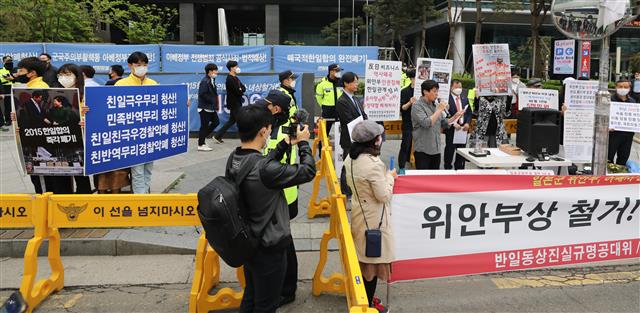 반아베반일청년학생공동행동 회원(왼쪽)들이 12일 서울 종로구 옛 일본대사관 앞 소녀상에서 열린 보수단체의 소녀상 철거 촉구 집회에서 맞서 피켓을 들고 소녀상 주변을 지키고 있다. 2020.5.12 뉴스1