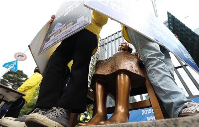 반아베반일청년학생공동행동 회원들이 12일 서울 종로구 옛 일본대사관 앞 소녀상에서 열린 보수단체의 소녀상 철거 촉구 집회에서 맞서 피켓을 들고 소녀상 주변을 지키고 있다. 2020.5.12 뉴스1