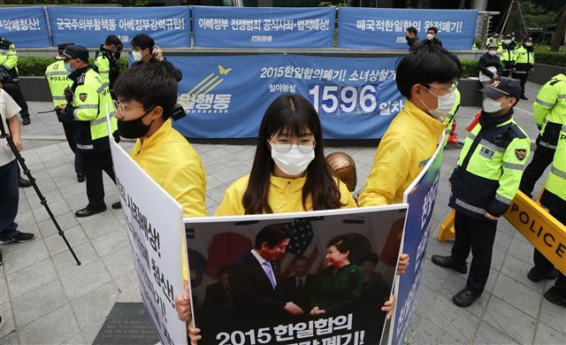 반아베반일청년학생공동행동 회원들이 12일 서울 종로구 옛 일본대사관 앞 소녀상에서 열린 보수단체의 소녀상 철거 촉구 집회에 맞서 피켓을 들고 소녀상 주변을 지키고 있다. 2020.5.12 뉴스1