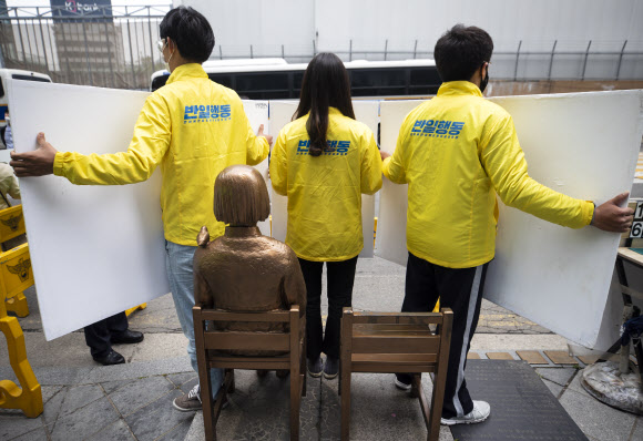 12일 서울 종로구 옛 일본대사관 앞에서 아베반일청년학생공동행동 회원들이 반일동상진상규명공대위의 소녀상 철거 및 수요집회 중단 촉구 기자회견에 맞서 소녀상을 보호하고 있다. 2020.5.12 연합뉴스