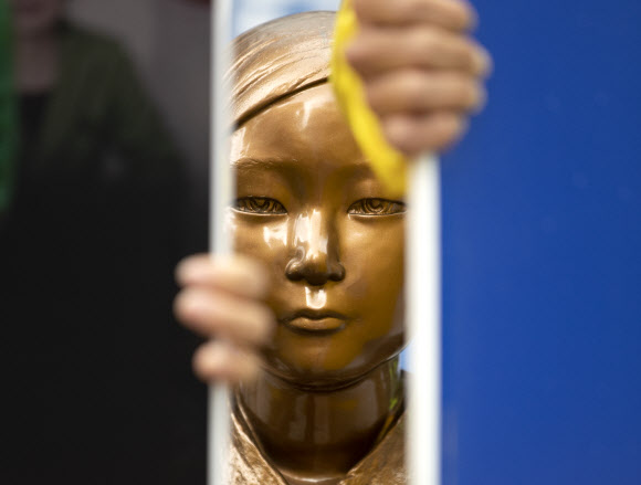 12일 서울 종로구 옛 일본대사관 앞에서 아베반일청년학생공동행동 회원들이 반일동상진상규명공대위의 소녀상 철거 및 수요집회 중단 촉구 기자회견에 맞서 소녀상을 보호하고 있다. 2020.5.12  연합뉴스