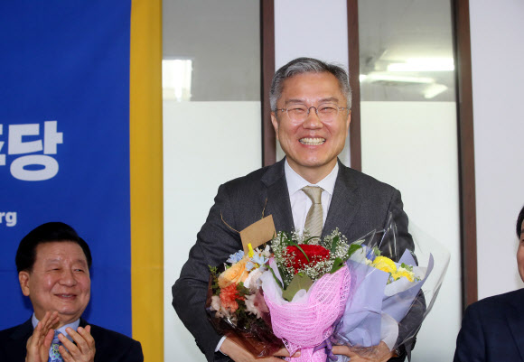 열린민주당 최강욱 신임 당 대표가 12일 서울 여의도 당사에서 축하 꽃다발을 받고 있다. 2020.5.12 연합뉴스