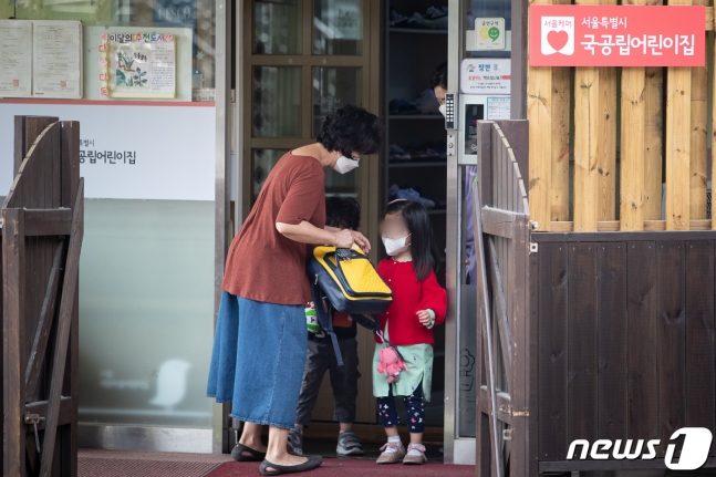 12일 서울시내 한 어린이집에서 한 할머니가 두 손자 손녀를 긴급돌봄을 위해 등원시키고 있다. 뉴스1