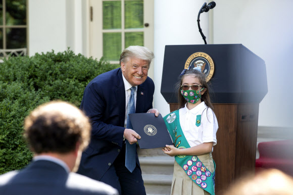 도널드 트럼프 미국 대통령이 15일(현지시간) 미국 워싱턴DC 백악관 로즈 가든에서 열린 ‘Hard Work, Heroism, and Hope’에 대한 대통령 표창식에서  걸스카우트 로렌 매트니와 함께 사진을 찍기 위해 포즈를 취하고 있다. EPA 연합뉴스