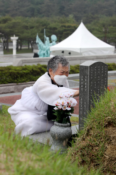 5·18민주화운동 40주년을 하루 앞둔 17일 오전 광주 북구 국립 5·18민주묘지에서 5·18희생자 유가족이 묘비를 매만지고 있다. 2020.5.17  연합뉴스