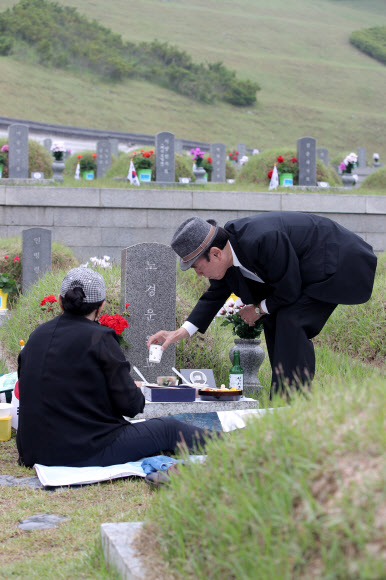 5·18민주화운동 40주년을 하루 앞둔 17일 오전 광주 북구 국립 5·18민주묘지에서 5·18희생자 유가족이 제사상을 차리고 있다. 2020.5.17  연합뉴스