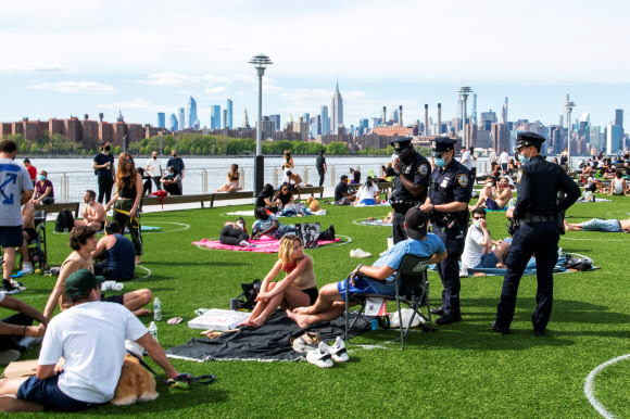 뉴욕 시민들이 16일(현지시간) 브루클린 도미노파크에서 코로나19 확산을 막기위해 사회적 거리를 유지하며 오후 햇살을 즐기고 있다. 로이터 연합뉴스